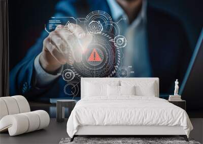  A businessman interacts with a digital interface displaying a warning symbol, highlighting cybersecurity measures and the monitoring of potential cyber threats within corporate systems. Wall mural