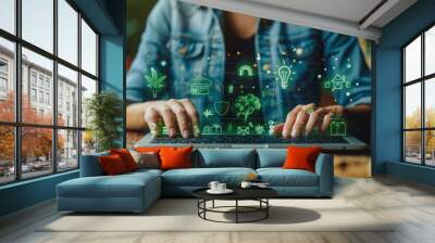 Eco-Strategy Interface: A person in a denim shirt uses a laptop with floating sustainability icons like a plant light bulb, recycling symbol, and a house with a leaf, emphasizing green initiatives. Wall mural