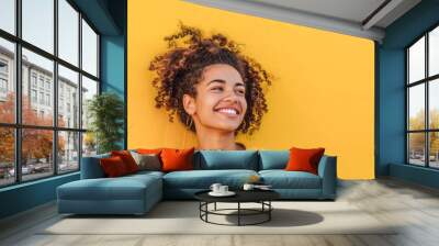 Joyful young woman, vibrant yellow backdrop, epitomizing positivity and energy in a professional light Wall mural