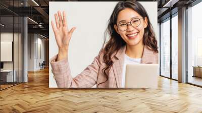 
Smiling Asian businesswoman with laptop, waving at camera on white background. Ideal for professional greetings. Space for text. Wall mural