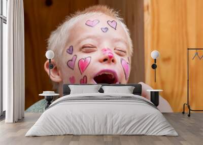 Preparing and painting the face of a boy with the down syndrome to the house show. Wall mural