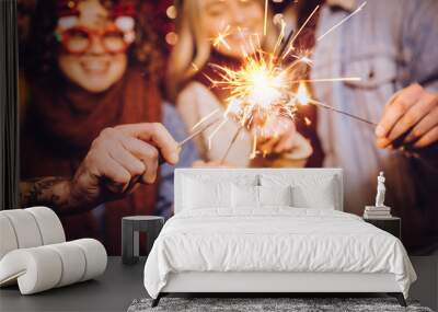 Close view of sparklers. Group of happy friends celebrating New Year with sparklers. New year party. Wall mural