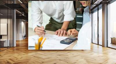 Engineers looking and discussing over blueprints on desk. Wall mural