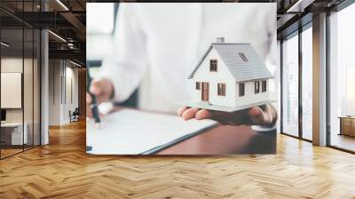 House model with real estate agent and customer discussing for contract to buy house, insurance or loan real estate background. Wall mural