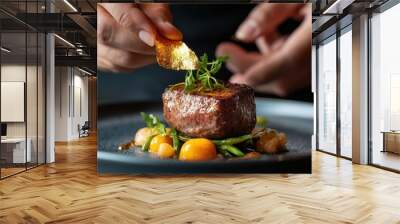 Chef garnishing gourmet steak with herbs and gold leaf, beautifully plated. Wall mural