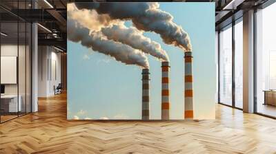 Industrial chimneys emitting smoke into the sky at sunset, representing pollution and environmental impact of industrial activities. Wall mural