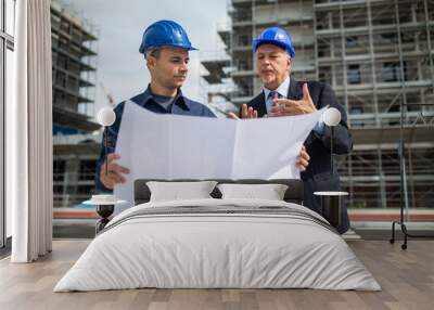 Architect talking to the site manager in front of a construction site building Wall mural