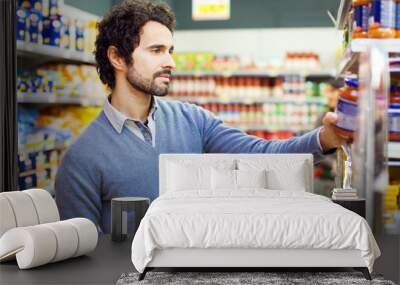 attractive man shopping in a supermarket Wall mural