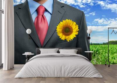 Businessman keeping a sunflower in his pocket Wall mural