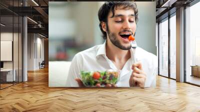 man eating a salad on the sofa Wall mural