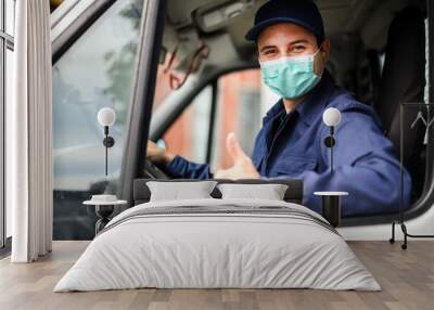 Portrait of a van driver giving thumbs up and wearing a mask, coronavirus concept Wall mural