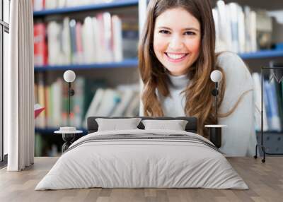 Smiling girl in a library Wall mural