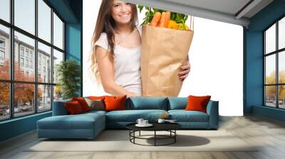 Smiling woman holding a bag full of vegetables Wall mural