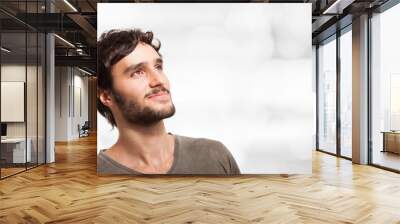 smiling young man looking up Wall mural