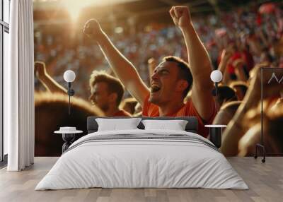 Young man cheering with arms raised at soccer stadium Wall mural