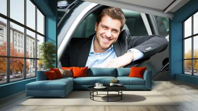 Young man sitting in a car Wall mural