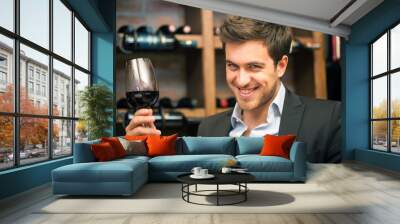 Young man tasting red wine Wall mural