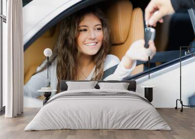 Young woman receiving the keys of her new car Wall mural