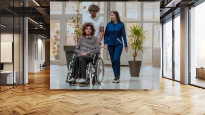 An Afro American doctor accompanied by a caring nurse, compassionately transports a patient in a wheelchair through the modern hospital, demonstrating their dedication to providing inclusive Wall mural