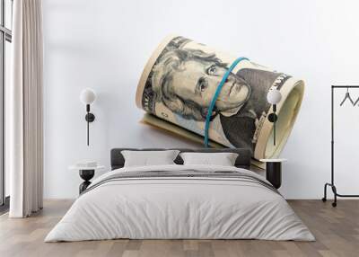 A roll up bundle of US dollar bills isolated in a white background. Wall mural