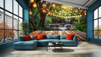 Empty wood table for product display with decorative outdoor string lights hanging on tree at night time. Wall mural