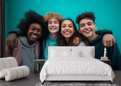 Group Of Diverse Teenagers Laughing And Embracing Each Other Against A Bright Blue Background Wall mural