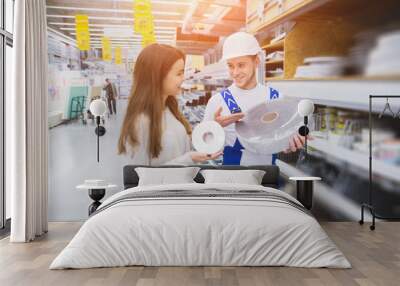 friendly hardware store assistant helping woman choosing taps Wall mural