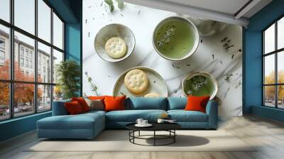 A serene tea setup featuring green tea, delicate cookies, and fresh herbs on a marble table, perfect for relaxation. Wall mural