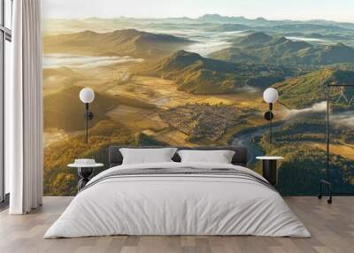 Vibrant aerial view of a serene valley landscape at sunrise with mist and mountains Wall mural