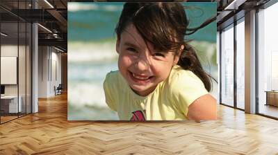  beautiful smiling girl posing on the seashore near a wooden pier. Wall mural