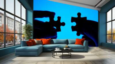 hands joining puzzle pieces. Wall mural