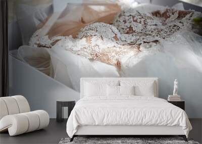 Beautiful luxury wedding dress in white box on bed, copy space. Bridal morning preparations. Wedding concept Wall mural