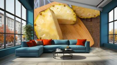 Two pieces of pineapple sliced on a board kept on a table with copy space Wall mural