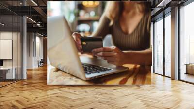 Woman making a business payment online with a credit card at a cafe table Wall mural