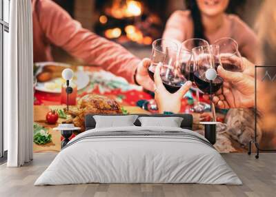 Family toasting red wine and having fun at Christmas supper party - Holiday celebration concept with happy people enjoying winter time together at home dinner fest - Warm filter with focus on glasses Wall mural