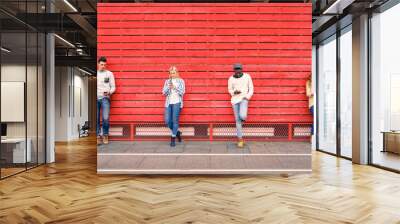 group of multiracial fashion friends using smartphone with red wood background - technology addictio Wall mural