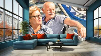 Happy senior couple in travel moment on sightseeing bus - Concept of active elderly during retirement - Wanderlust concept with mature people spending free time together - Sunny afternoon color tones Wall mural