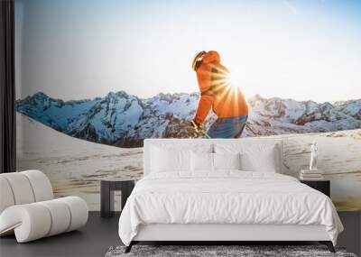 Professional skier athlete skiing at sunset on top of french alps ski resort - Winter vacation and sport concept with adventure guy on mountain top riding down the slope - Warm bright sunshine filter Wall mural