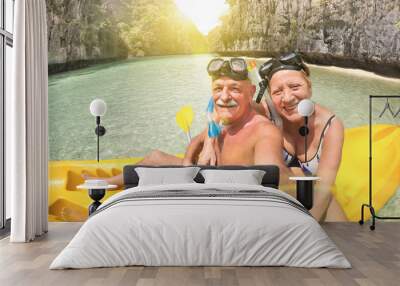 Senior happy couple taking selfie on kayak at Big Lagoon in El Nido Palawan - Travel to Philippines wonders - Active elderly concept around the world - Lens flare and sun halo are part of composition Wall mural