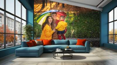 Happy funny family with colourful umbrella under the autumn rain. Wall mural