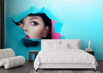 Young beautiful woman with clean perfect skin through gap in cardboard Wall mural