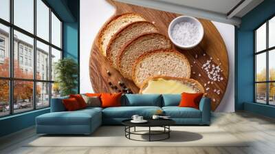 Wooden board of bread slices with fresh butter, peppercorn and salt on white background Wall mural