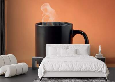 Black mug with hot tea on a pastel orange background, steam rising, soft lighting, modern look. Wall mural