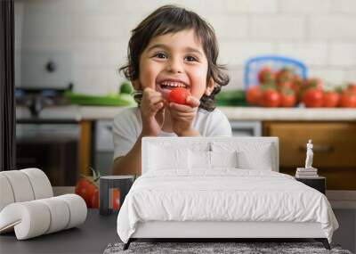 Happy hispanic girl sitting on table eating fresh tomato with smile. Young child enjoying healthy food with confident expression. Casual attire, long hair, and bright smile. Wall mural