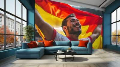 Vibrant stadium scene captures a man holding aloft a large Belgium flag against the backdrop of seating area. High-energy atmosphere evokes excitement and passion. Wall mural