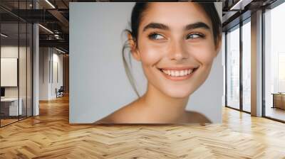 Young beautiful woman with clear and pure skin. Clean skincare wearing natural makeup. Perfect complexion, fresh and healthy. Smiling happy looking with perfect facial expression. Wall mural