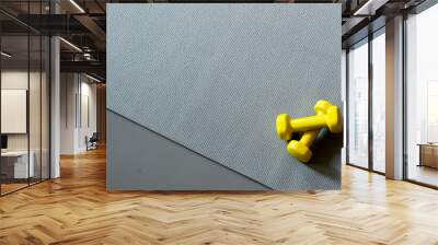 two yeallow dumbells on the grey yoga mat Wall mural