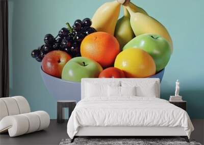 Fresh Fruit Bowl with Apples  Oranges  Grapes and Bananas on a Blue Background Wall mural