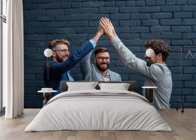 Happy Businessmen Giving High Five in Front of Brick Wall Wall mural