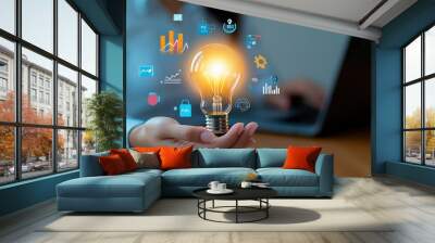 Woman holding lightbulb with glowing icons  business idea concept Wall mural